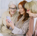 group of 3 womans looking on phone